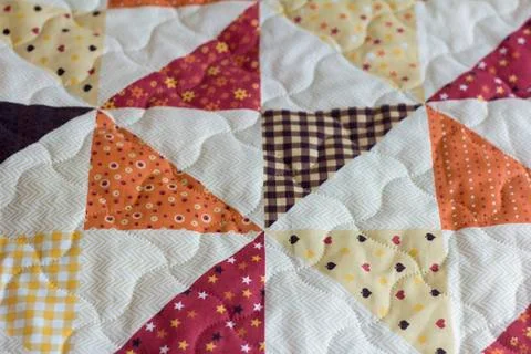A patchwork quilt or bedspread.A fragment of a patchwork quilt as a backgroun Stock Photos