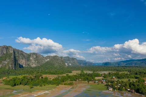 Patchwork rice paddies and limestone hills under blue sky 스톡 사진