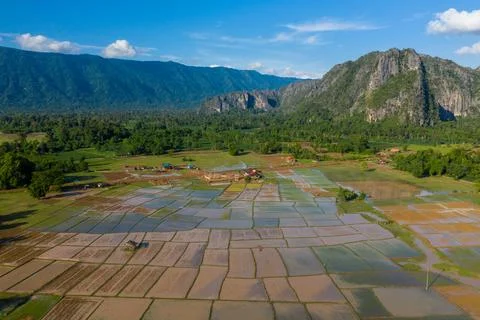 Patchwork rice paddies and limestone cliffs in Laos Stockfoto's