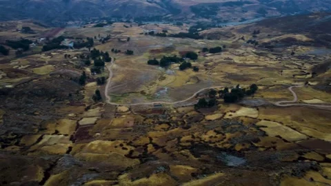 Patchwork of small Peruvian farms dry brown vegetation with small gravel road sn Video stock 251385846