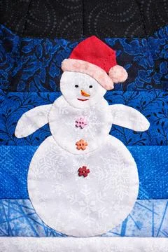 Patchwork snowman made out of pieces of fabric with texture of snowflakes Fotos de archivo