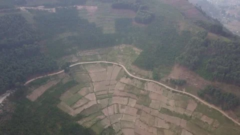 Patchwork Terraced Fields and Curving Dirt Road on Hazy Hillside, Kigezi Stock Footage 348115182