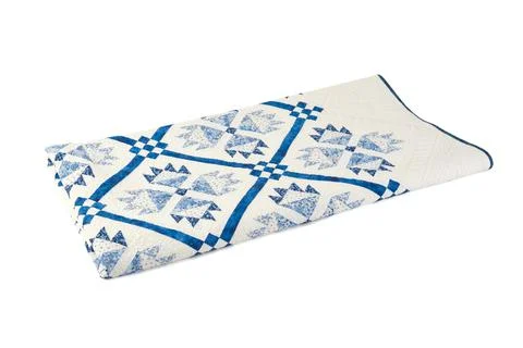 Patchwork white-blue quilt on a white background. Patchwork blanket. Handmade Stock Photos