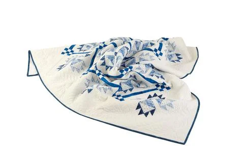 Patchwork white-blue quilt on a white background. Patchwork blanket. Handmade Stock Photos