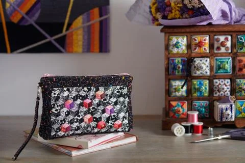Patchwork wristlet on the background wooden mini chest with ceramic drawers Stock Photos