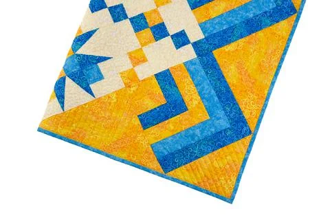 Patchwork yellow-blue quilt on a white background. Patchwork blanket. Handmad Stock Photos