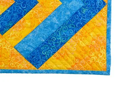 Patchwork yellow-blue quilt on a white background. Patchwork blanket. Handmad Stock Photos