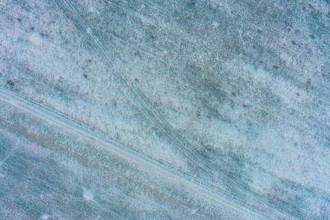 Patchy snow on dry field creating high contrast texture, winter abstract Stock Photos