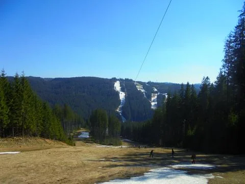 Patchy snow on mountain ski slope in spring, Beskydy, spruce forest Stock Photos