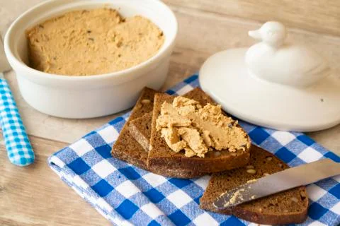 The pate of duck with bread on kitchen table. Stock Photos