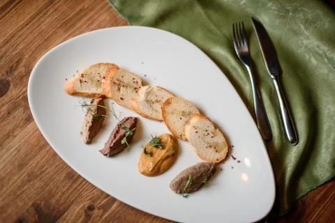 Pate set with garlic toasted bread on white plate on wooden table Stock-Fotos