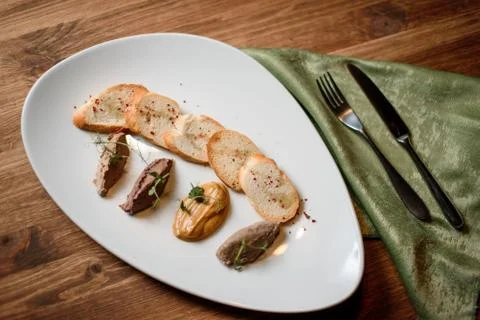 Pate set with garlic toasted bread on white plate on wooden table Фото