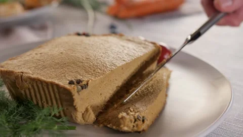 Pate on a white matte plate is cut with a table knife. Video stock 233170675