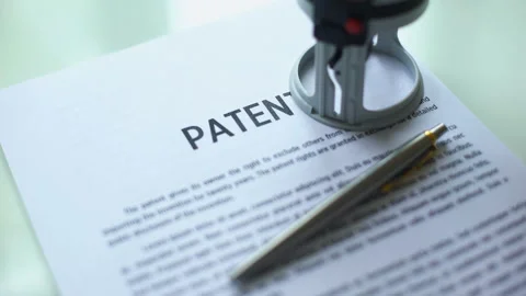 Patent document approved, hand stamping seal on official paper, copyright law Stock Footage 97282596
