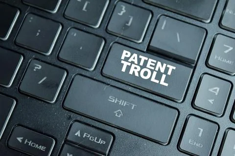 Patent troll on the button keyboard. Use of patent infringement claims Stock Photos