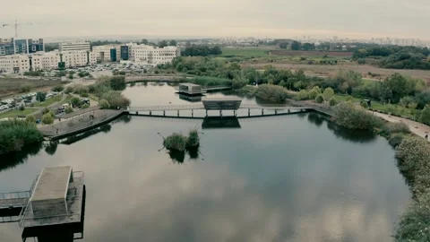 A path adjacent to the lake with reflection of clouds in the park Stock Footage 221413277