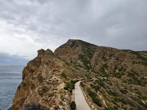 Path along sea cliffs, serpentine path above blue sea with rocky outcrops a.. Foto stock