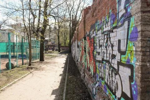 A path along the wall with graffiti. 库存照片