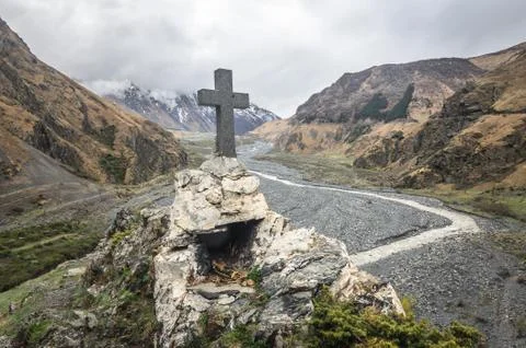 Path to ancient medieval monument in mountains of Caucasus. Christian cross i Stock Photos
