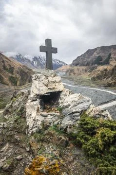 Path to ancient medieval monument in mountains of Caucasus. Christian cross i Stock Photos