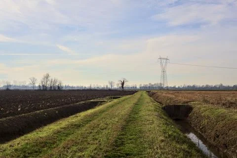 Path between cultivated fields and bordered by streams of water in the ital.. Stock Photos