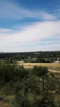 Path between the meadow, vegetation, mountains, sky with clouds Stock Photos