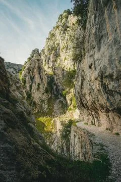Path between the rocky mountains with the walls filled with green grass Stock Photos