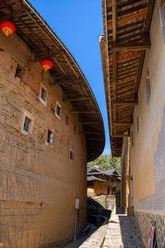 The path between two Tulou mud buildings with a blue sky, Fujian, China Stock Photos
