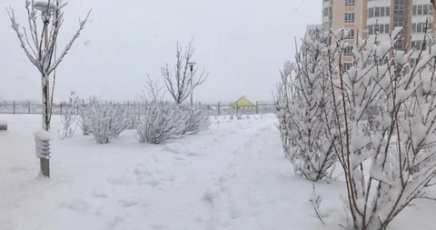 Path covered with snow, the yellow house behind the fence in the snowfall Vídeos de archivo 103251261