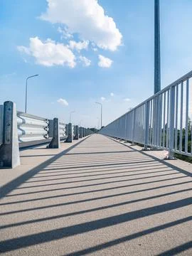 Path going along road fenced with railings and grid Stock-Fotos