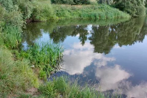Path by the lake, lake with clouds, clouds reflected in the water of the lake Stock Photos