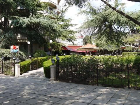 A path with lanterns on the background of the hotel with a cafe and fir trees Stock Photos
