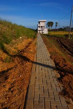 The path leads to a small white house against the blue sky Stock Photos