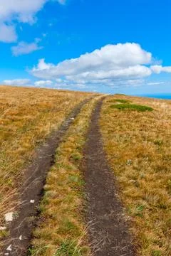 Path on mountain field in nice day Stock Photos