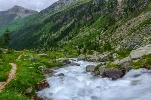 Path next to a mountain stream while hiking Stock Photos
