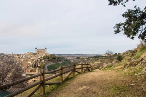 A path over the hill vith a view to Toledo Alcazar, evening at surroundings.. Stock Photos