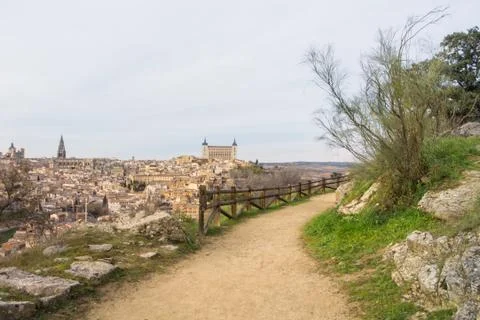 A path over the hill vith a view to Toledo Alcazar, evening at surroundings.. Stock Photos