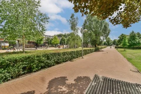 A path in a park with benches and trees Stock Photos