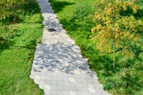 The path in the park lined with paving slabs in the form of a diamond. Stock Photos