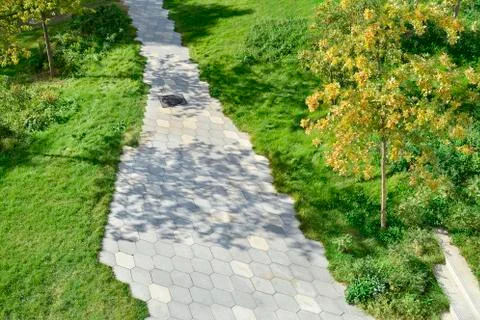 The path in the park lined with paving slabs in the form of a diamond. Stock Photos