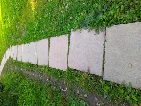Path in the park is made of concrete square slabs Foto stock