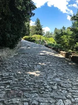 The path in the park is paved with stone. Decorative trail or road in the gar Stock Photos