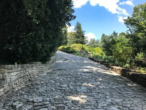 The path in the park is paved with stone. Decorative trail or road in the gar Stock Photos