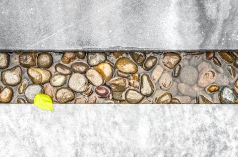 Path of pebble in water framed with stone. Stock Photos