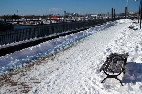 The path in the snow and the bench on the Morris Channel Basin Walkaway Stock Photos