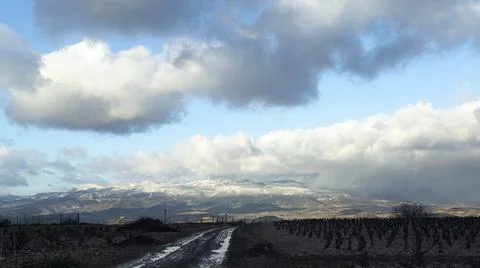 Path, snowy mountain and clouds Stock Photos