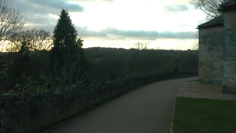 Path by stone wall with winter trees Stock Footage 104349950