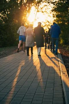 A path at sunset and passers-by Stock Photos
