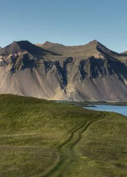 Path towards the mountains at the coast of southeast Iceland in Hofn Stock Photos