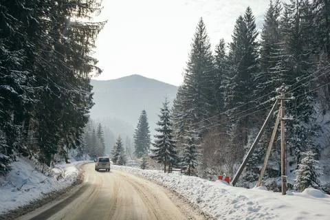 A path with trees on the side of a snow covered slope Stock Photos